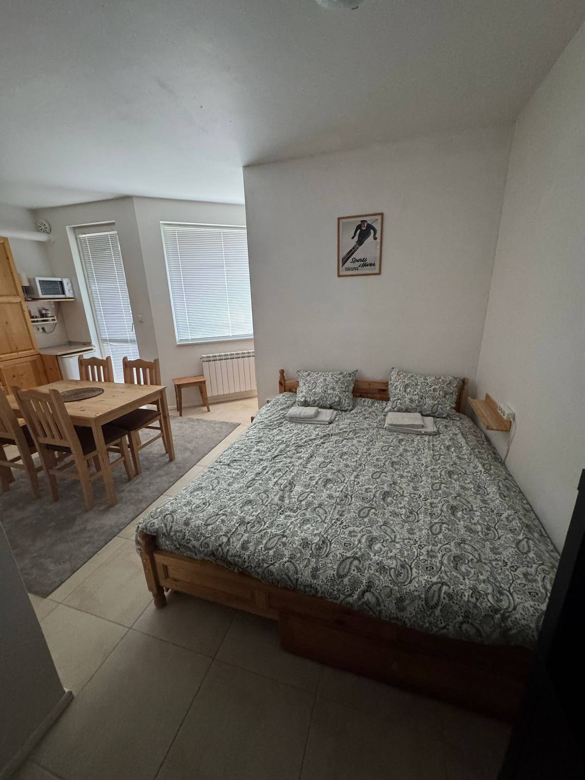 Queen bed and dining area at Borovets Pine Cabin